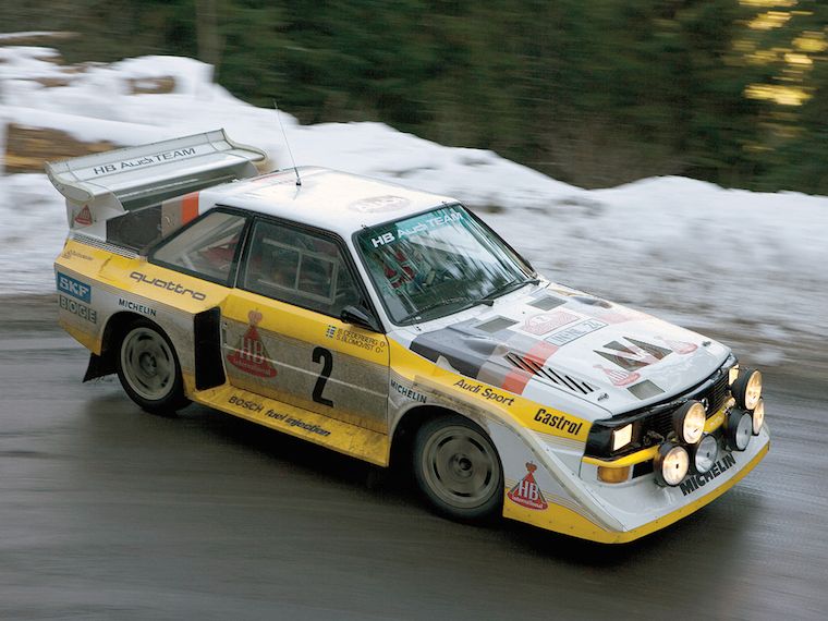 a rally car blasting around a corner on a rallystage in nature