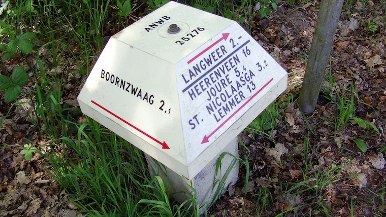 a clycling signpost showing directions to nearby villages and towns